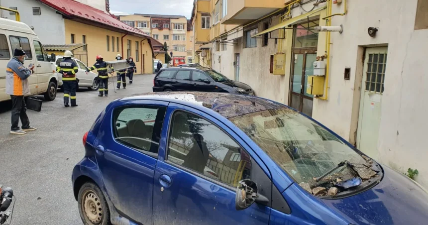 Mașină avariată de bucăți căzute de pe o clădire